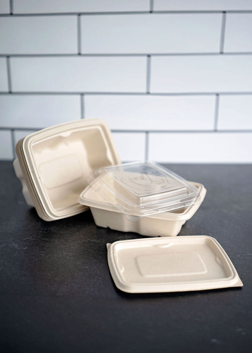 A stack of beige biodegradable anti leak bagasse food containers with clear lids. 